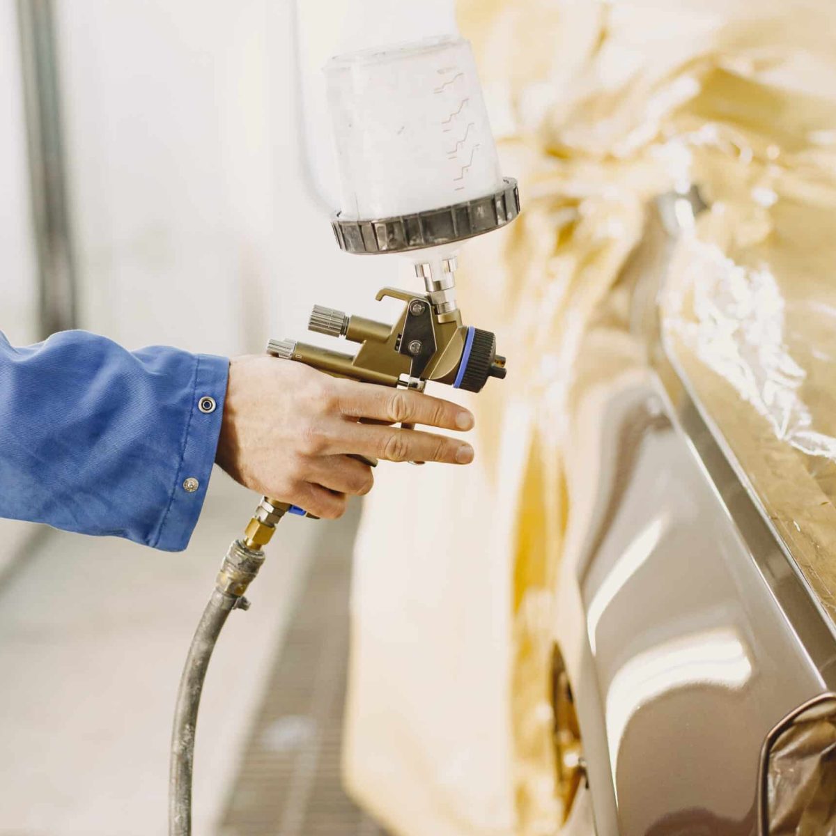 Painting of machine parts. White paint. Angle grinder.